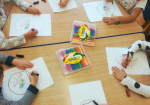 Dzieci wykonują kartę pracy – samodzielnie rysują wzór (koszyk) kredkami na karcie pracy tak, aby znajdujące się tam warzywa i owoce nalazły się w środku koszyka.